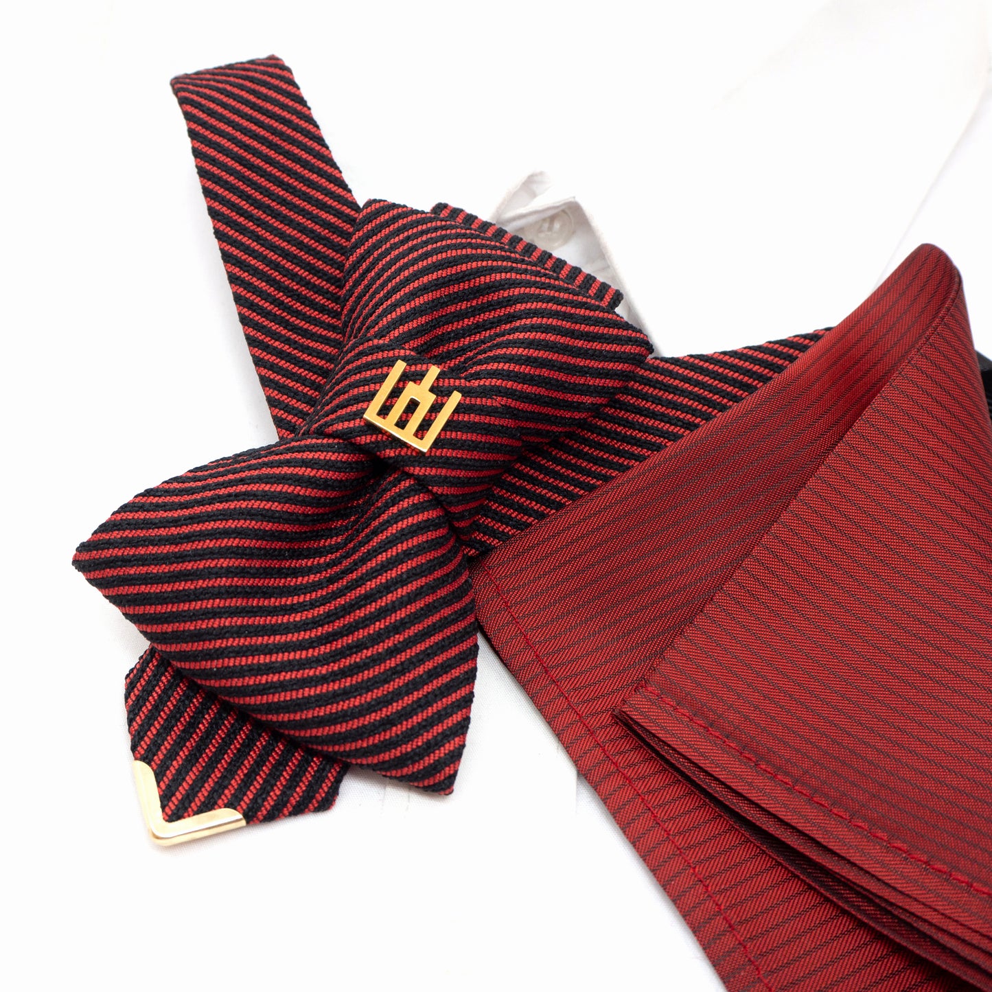 Red and black striped bow tie with a pocket square on a white background red black striped jabot tie, gold Gedimino stulpai emblem, handmade heritage necktie, Lithuanian cultural fashion, artisan jabot-style tie, elegant striped tie gold badge, luxury heritage necktie, cultural fashion accessory, Lithuanian identity tie, formal jabot tie, handcrafted Lithuanian motif tie