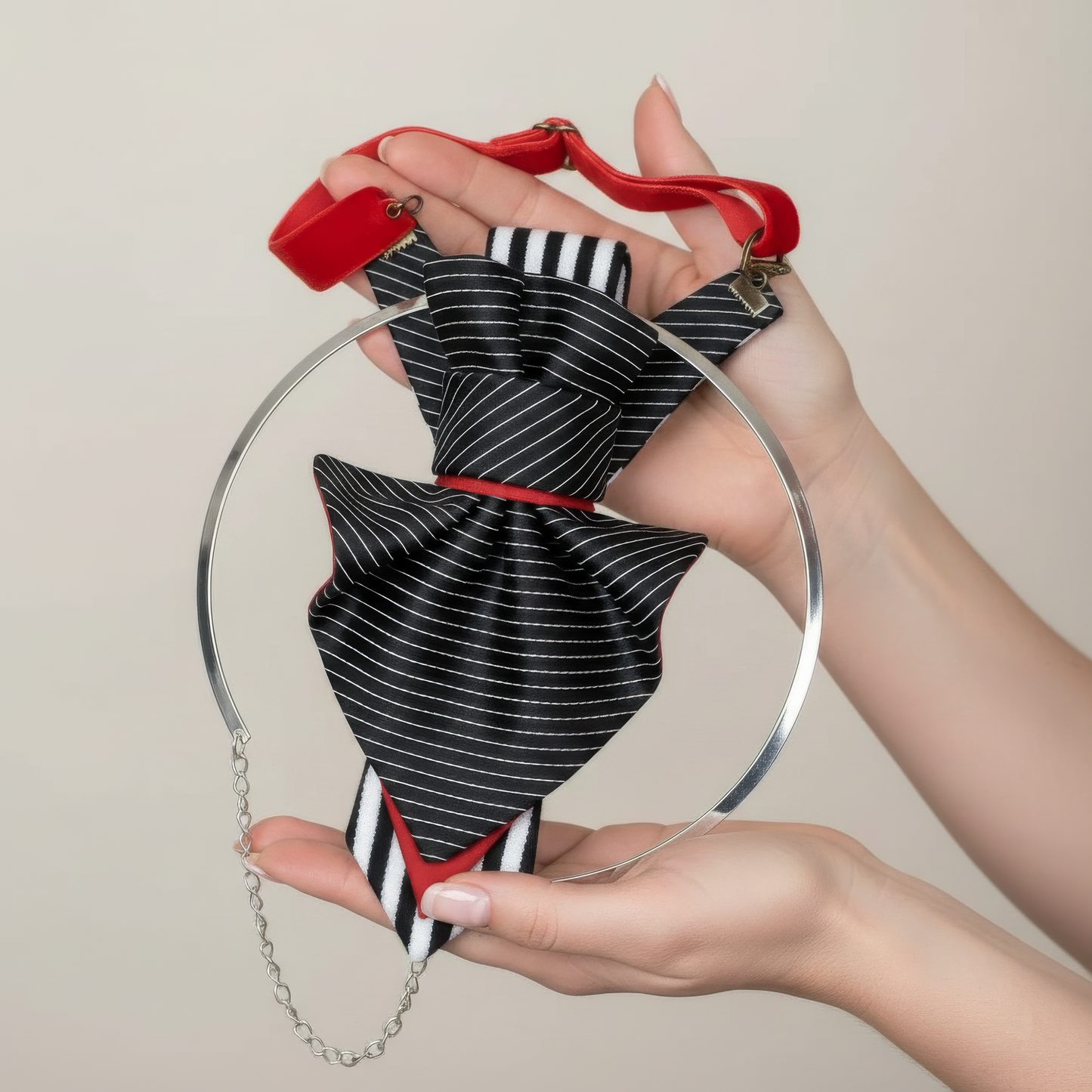 Black and white striped handbag with red accents held by a person against a neutral background Handmade black and white striped neck accessory, sculptural fabric necklace for women, artistic necktie style jewellery, modern textile statement necklace, avant-garde fashion neck ornament, unique handmade neck jewelry, graphic striped fabric necklace, contemporary wearable art accessory, designer fabric neckwear, bold black white neckpiece, abstract sculptural necklace, artistic women neck accessory, modern stat