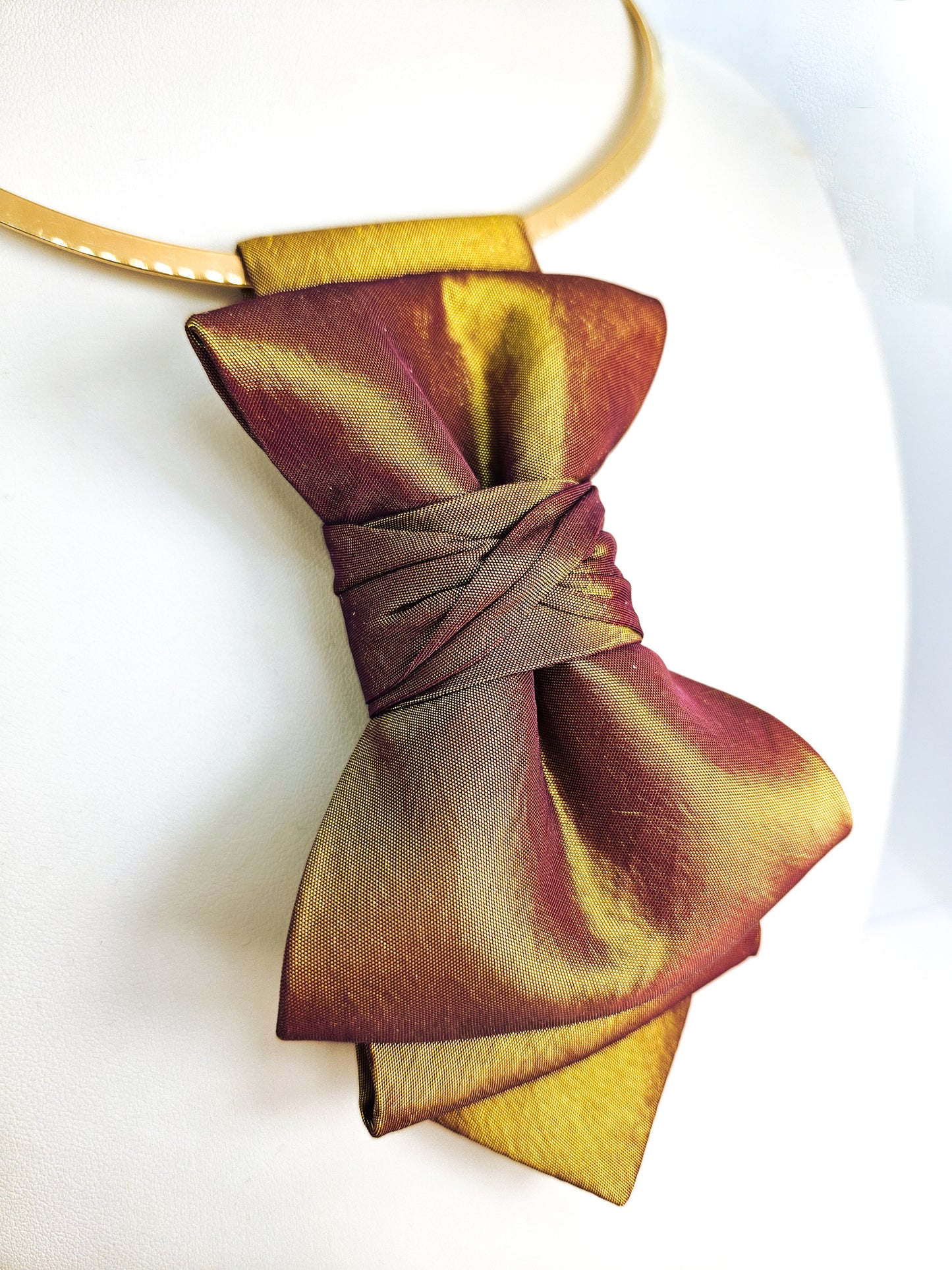 Gold and purple bow tie on a white background metallic plum gold womens necktie, bronze burgundy metallic bow tie for women, chameleon fabric neck accessory, handmade statement necktie, sculptural womens neckwear, metallic plum bronze neckpiece, luxury handmade womens neck accessory, artistic fabric necktie, modern designer womens bow tie, elegant metallic neckwear, unique womens fashion necktie, gold burgundy neck accessory, contemporary statement neckpiece