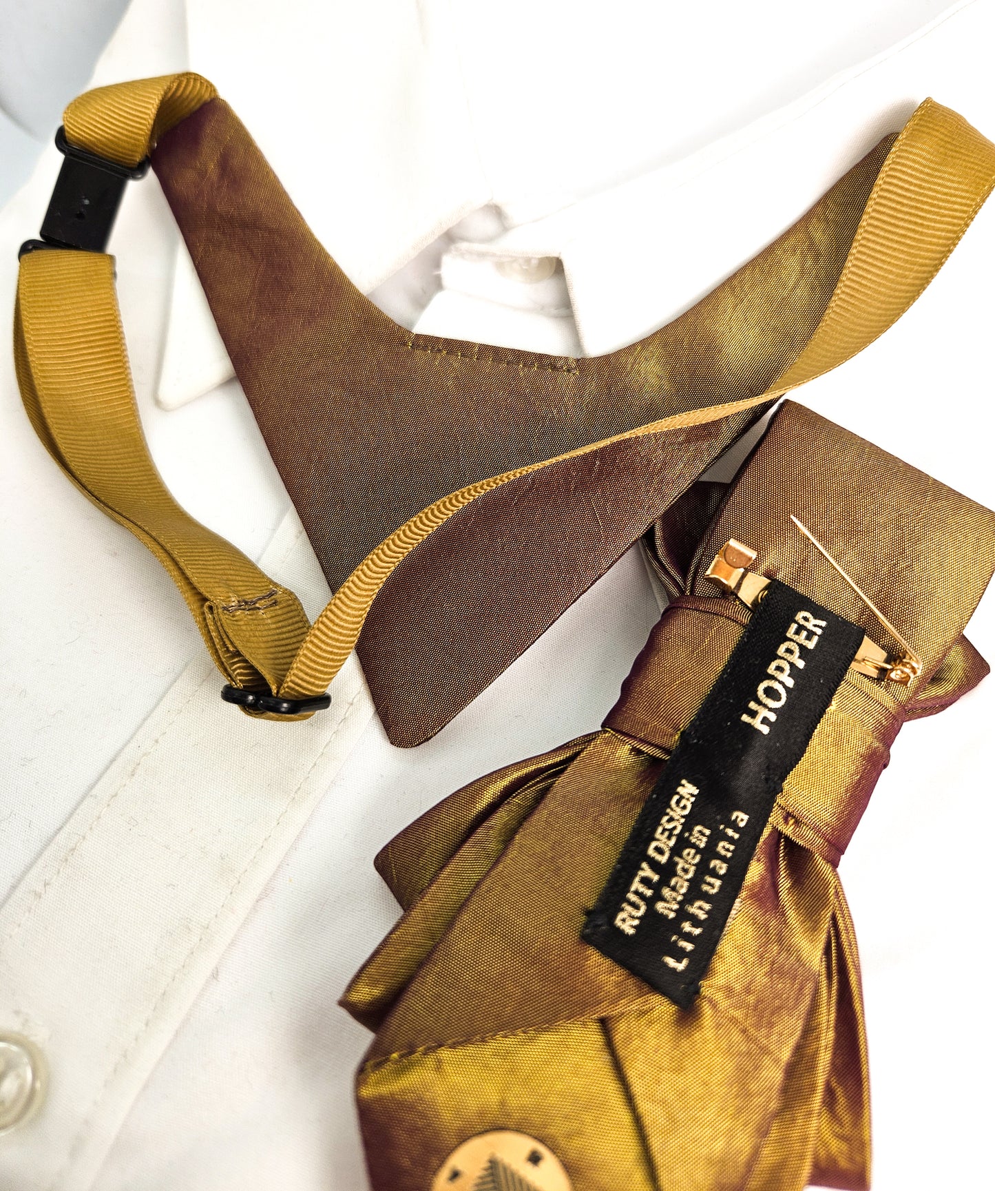Brown leather vest with yellow suspenders and a visible brand tag on a white background metallic plum gold womens necktie, bronze burgundy metallic bow tie for women, chameleon fabric neck accessory, handmade statement necktie, sculptural womens neckwear, metallic plum bronze neckpiece, luxury handmade womens neck accessory, artistic fabric necktie, modern designer womens bow tie, elegant metallic neckwear, unique womens fashion necktie, gold burgundy neck accessory, contemporary statement neckpiece