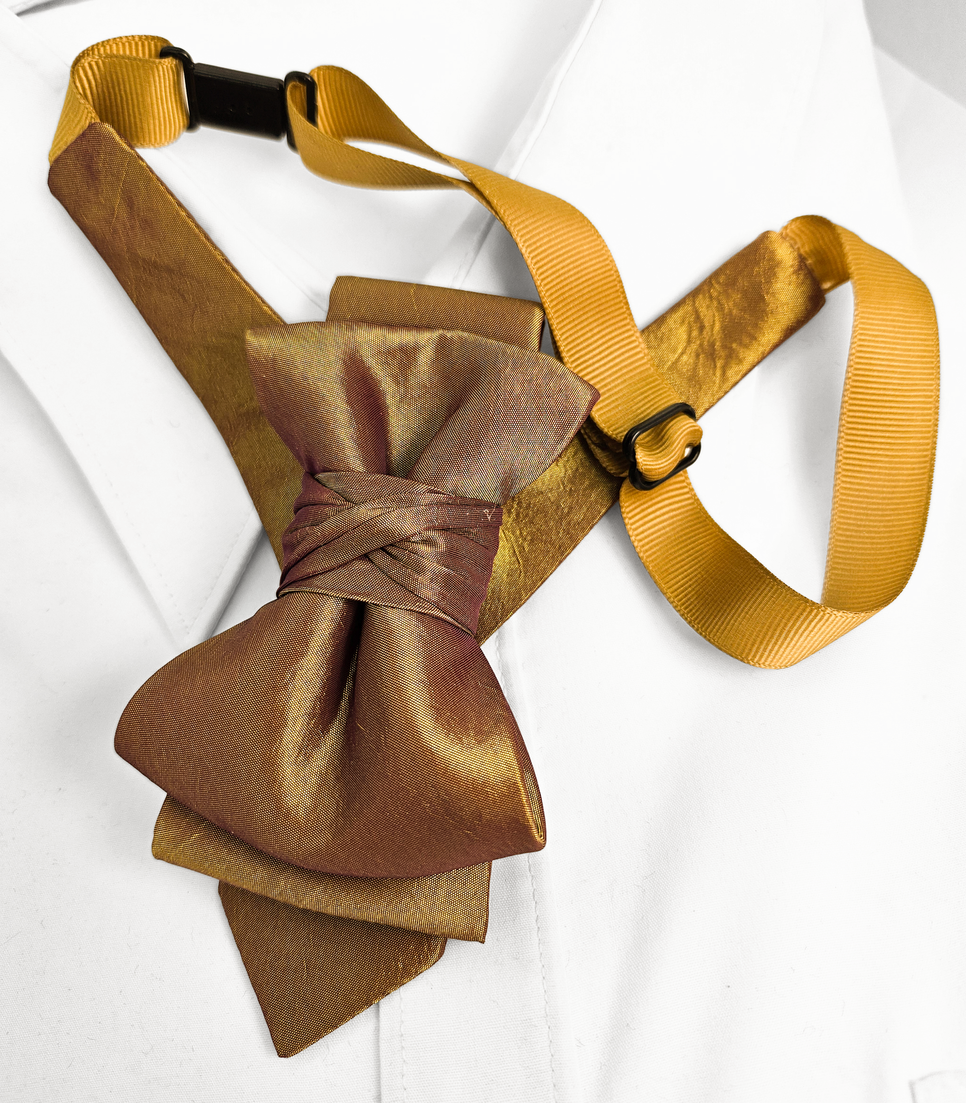 Gold bow tie and matching strap on a white background Brown bow tie with yellow straps on a white background metallic plum gold womens necktie, bronze burgundy metallic bow tie for women, chameleon fabric neck accessory, handmade statement necktie, sculptural womens neckwear, metallic plum bronze neckpiece, luxury handmade womens neck accessory, artistic fabric necktie, modern designer womens bow tie, elegant metallic neckwear, unique womens fashion necktie, gold burgundy neck accessory, contemporary statem