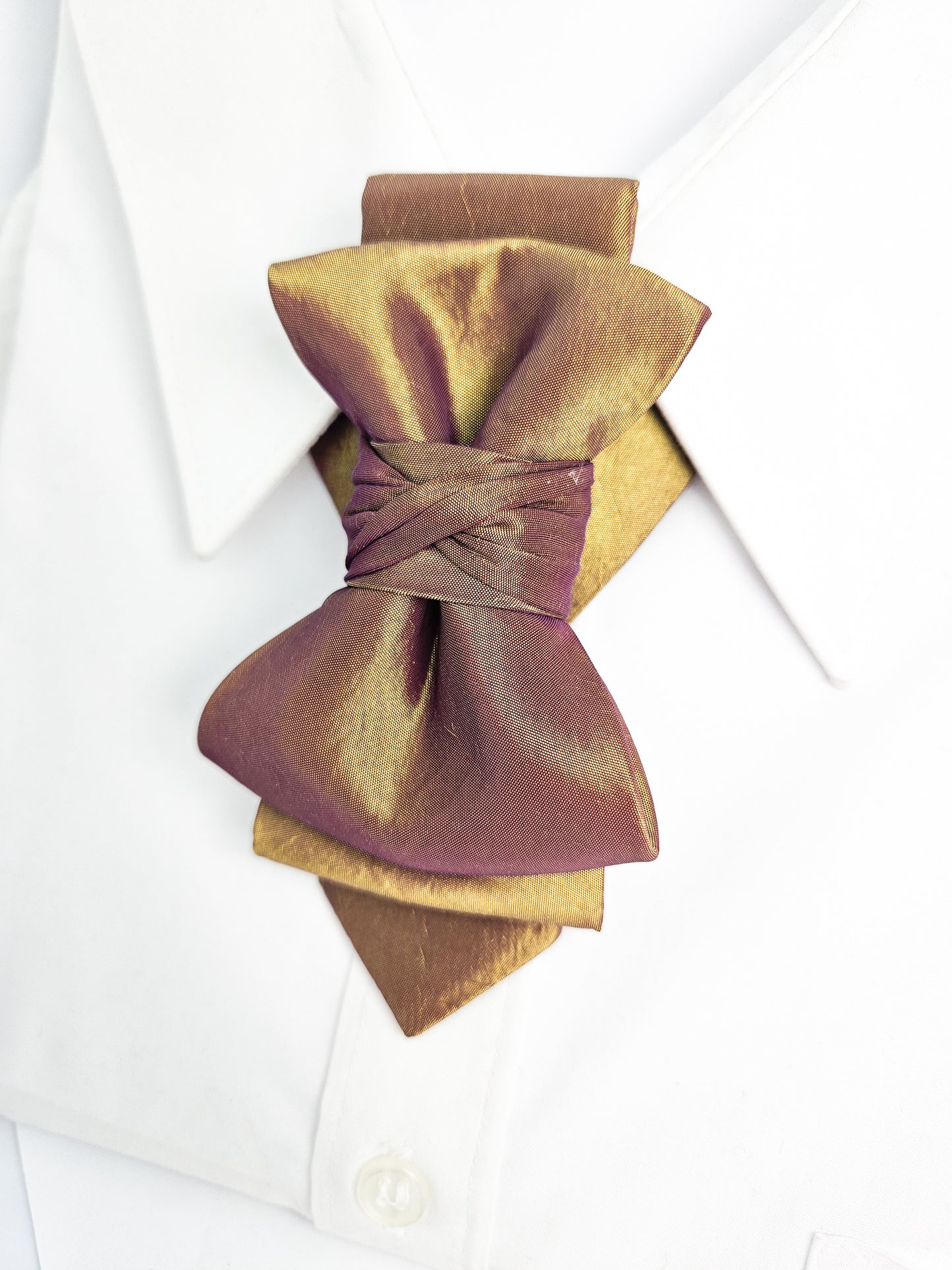Gold and brown bow tie on a white shirt with a white background metallic plum gold womens necktie, bronze burgundy metallic bow tie for women, chameleon fabric neck accessory, handmade statement necktie, sculptural womens neckwear, metallic plum bronze neckpiece, luxury handmade womens neck accessory, artistic fabric necktie, modern designer womens bow tie, elegant metallic neckwear, unique womens fashion necktie, gold burgundy neck accessory, contemporary statement neckpiece