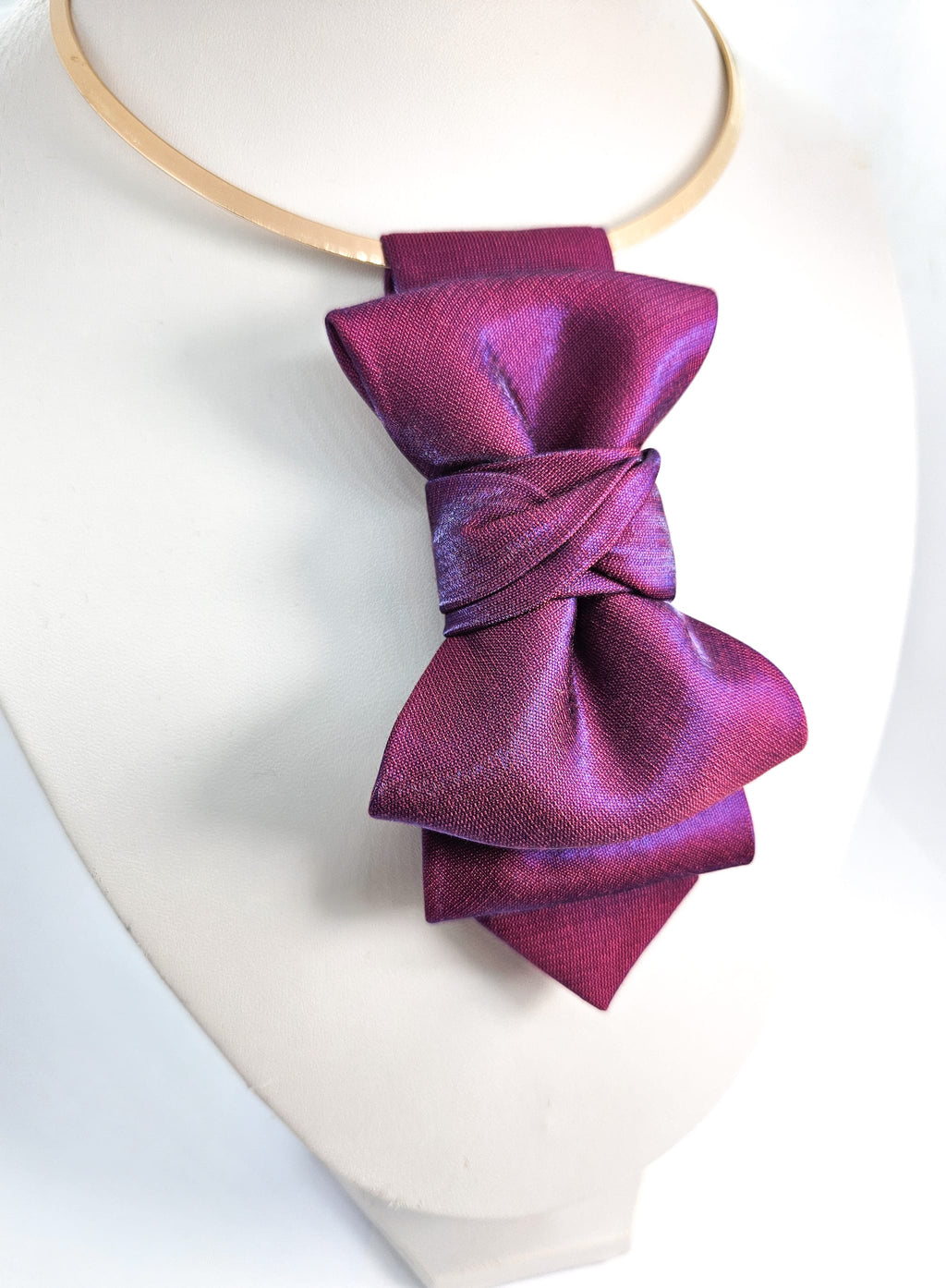 Purple bow tie on a mannequin with a white background fashionable, elegant, sophisticated, chic, modern, unique, exclusive, luxurious, high-end, premium, quality, handmade, artisan, bespoke, tailored, custom, designer, trendy, vogue, modish, smart, classy, stylish, fashion-forward, contemporary, women's fashion, ladies' wear, apparel, clothing, attire, garment, outfit, ensemble, get-up, dress, gown, frock, top, blouse, shirt, sweater, jacket, coat, blazer, skirt, trousers, pants, jeans, shorts, leggings, ju