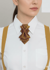 Person wearing a white shirt with a brown bow tie and suspenders on a plain background metallic plum gold womens necktie, bronze burgundy metallic bow tie for women, chameleon fabric neck accessory, handmade statement necktie, sculptural womens neckwear, metallic plum bronze neckpiece, luxury handmade womens neck accessory, artistic fabric necktie, modern designer womens bow tie, elegant metallic neckwear, unique womens fashion necktie, gold burgundy neck accessory, contemporary statement neckpiece