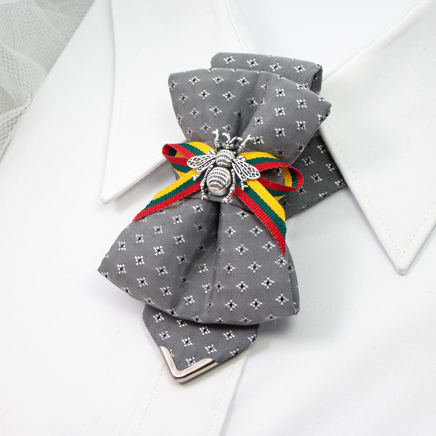 Bow tie "Bitute pilkoji" is a work, dedicated to the birthday of Vilnius, the capital of Lithuania.  Brass Vytis adorns the original knot of three fabrics. Keistas kaklaraištis, nematyta peteliškė, Vilniaus kaklaraištis, Kaklaraištis žiogas, keista varlytė