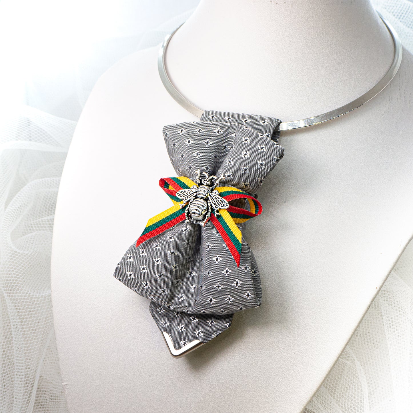 Bow tie "Bitute pilkoji" is a work, dedicated to the birthday of Vilnius, the capital of Lithuania.  Brass Vytis adorns the original knot of three fabrics. Keistas kaklaraištis, nematyta peteliškė, Vilniaus kaklaraištis, Kaklaraištis žiogas, keista varlytė