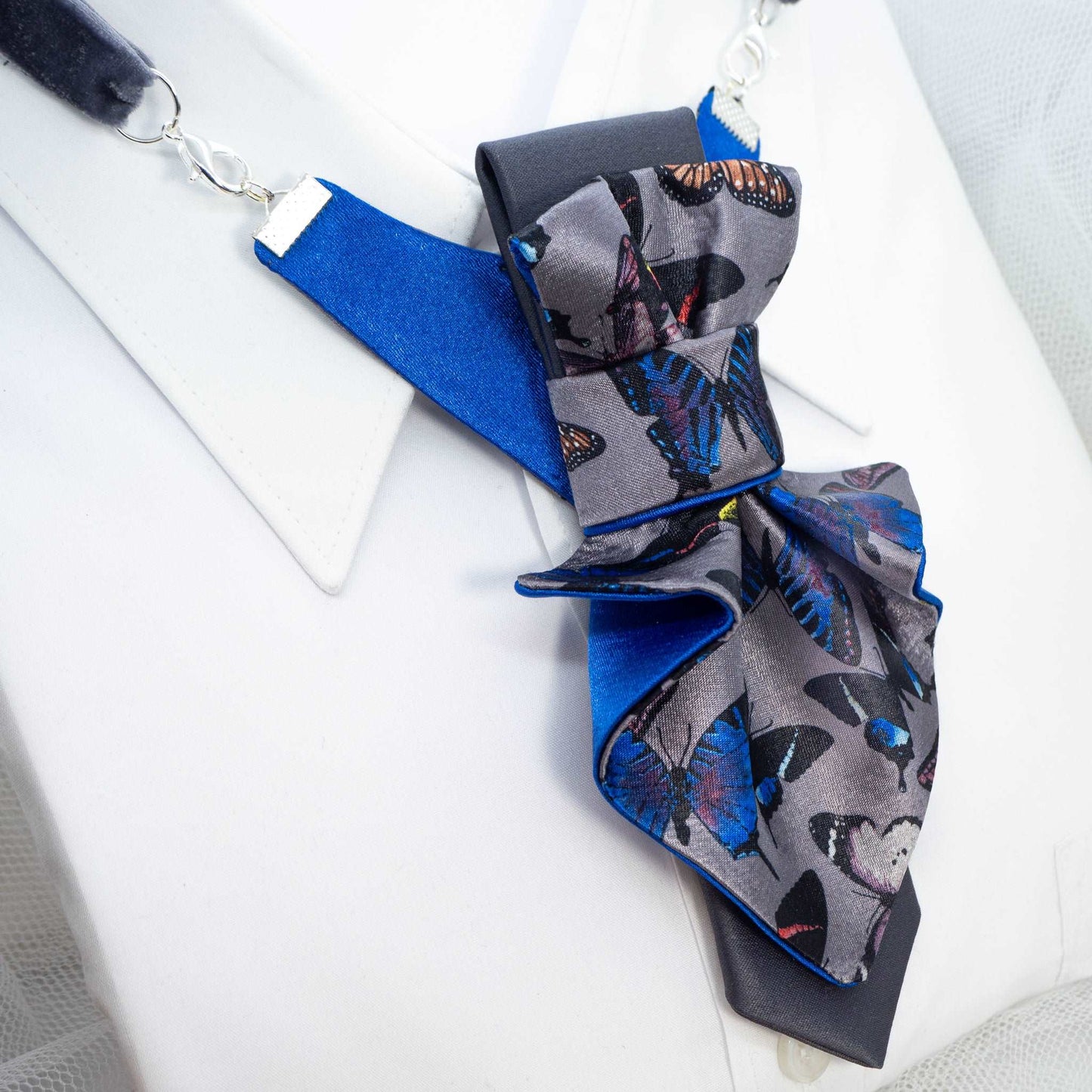 Jabot Blue tie for women, Blue bow tie for ladies side view Jabot blue tie for women, blue bow tie for ladies, handmade luxury women’s necktie, butterfly jabot tie, gray and blue butterfly pattern tie, artistic women’s neck accessory, statement bow tie for women, sculptural fabric tie accessory, modern jabot necklace tie, elegant women’s tie for weddings, unique designer necktie for women, butterfly print fashion accessory, avant garde women’s tie, luxury handmade tie Lithuania, Rūta Piekurienė design tie, 
