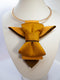 A unique vertical women's bow tie in mustard yellow handmade luxury neck accessory, women statement tie, vertical bow tie for women, gold satin necktie, elegant women tie, unique bow tie alternative, luxury handmade tie, artistic neckwear for women, modern formal accessory, gold statement necklace tie, designer women necktie, wedding guest accessory women, avant garde fashion tie, silk bow tie alternative, bold women fashion accessory, golden necktie women, formal outfit statement piece stylish office acces