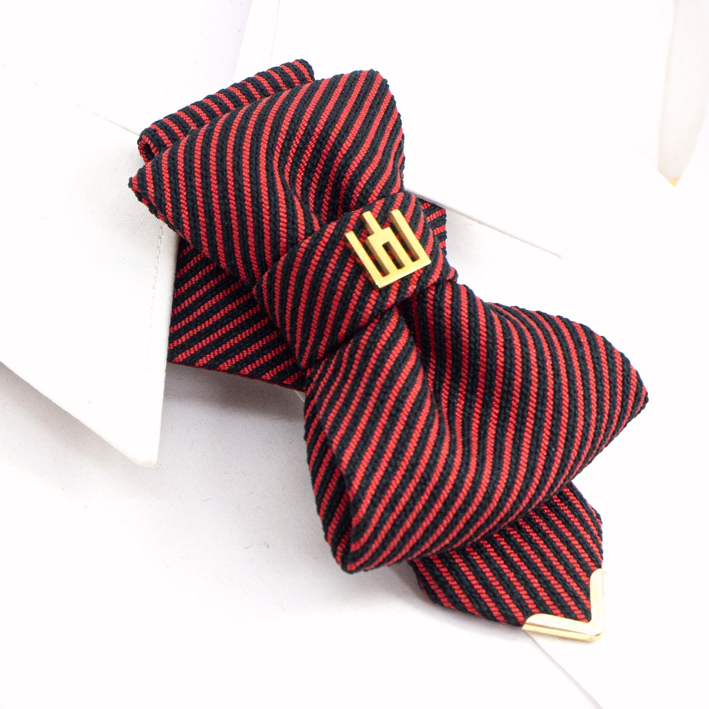 Red and black striped bow tie with a gold emblem on a white background red black striped jabot tie, gold Gedimino stulpai emblem, handmade heritage necktie, Lithuanian cultural fashion, artisan jabot-style tie, elegant striped tie gold badge, luxury heritage necktie, cultural fashion accessory, Lithuanian identity tie, formal jabot tie, handcrafted Lithuanian motif tie