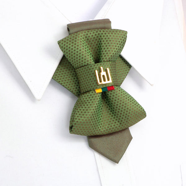 Green bow tie with a brand logo on a white background  Handmade green jabot-style tie with Gediminas Columns symbol and Lithuanian tricolor ribbon, luxury heritage necktie for weddings and cultural events.