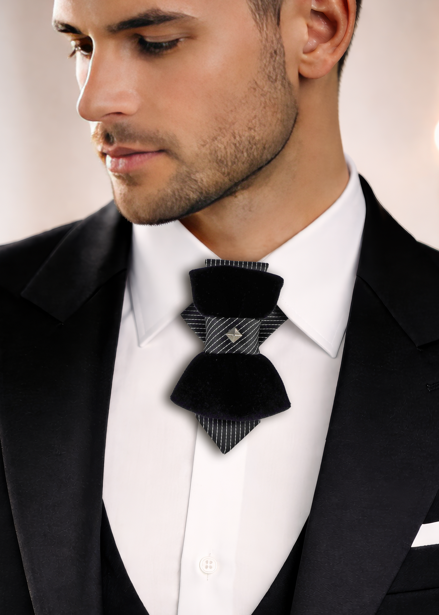 Man wearing a black bow tie with a patterned design on a blurred  lack Velvet Vertical Bow Tie “Pompea” – Designer Statement Tie for Groom, Weddings & Elegant Style
The Hopper Tie “Pompea” is an original designer piece created for those moments when ordinary style is not enough. Combining the elegance of a classic necktie with the distinctive shape of a bow tie, this vertical bow tie creates a look that is refined, artisbackground