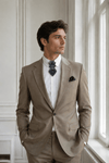 Man wearing a beige suit with a white shirt and patterned tie in a room with large windows Man in a formal suit standing in a train station Handmade luxury black bow tie for weddings, Black wedding bow tie, Unique artistic black necktie for stylish men, Designer black bow tie for grooms and musicians, Elegant black wedding bow tie by Rūta Piekurienė, High-end handmade black tie for special occasions, Artistic luxury black bow tie for men, Unique wedding bow tie crafted by Rūta Piekurienė