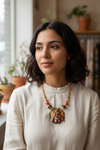 Woman wearing a necklace with a large pendant indoors