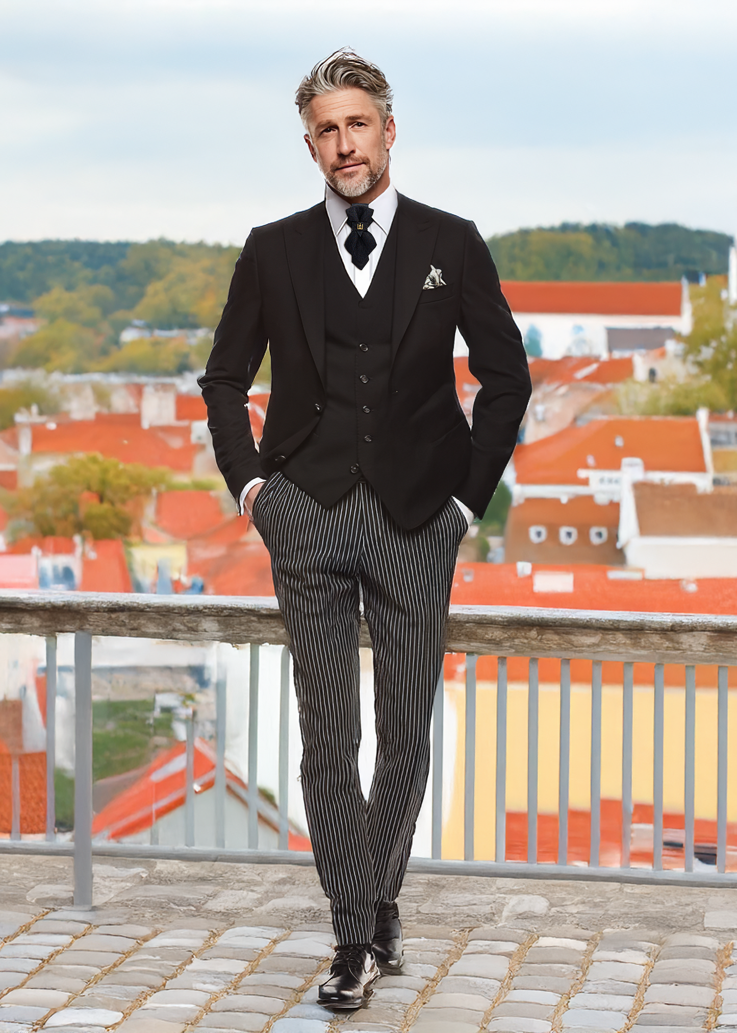 Man in a formal black suit with a white shirt and tie, standing on a rooftop with a cityscape background. Handmade luxury black  bow tie with leather neck strap and unique gold-tone monogrammed clip. Pre-tied cravat for groom, weddings, formal events, and special occasions. Perfect sophisticated men's accessory.