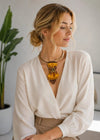 Elegant woman wearing a handmade gold bow tie with a bumblebee brooch accessory
