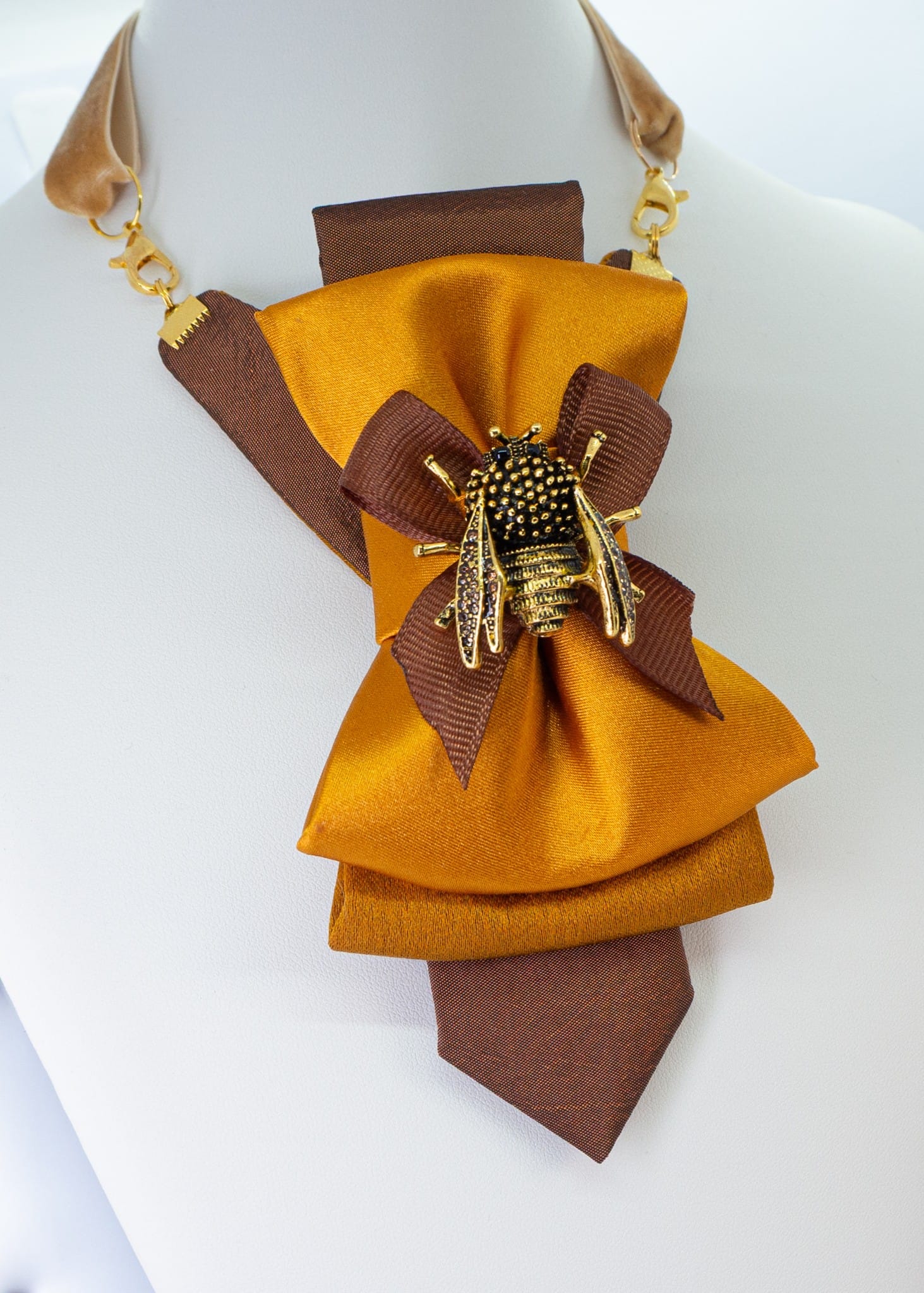 Gold-toned women's necktie with a golden bumblebee brooch and velvet strap