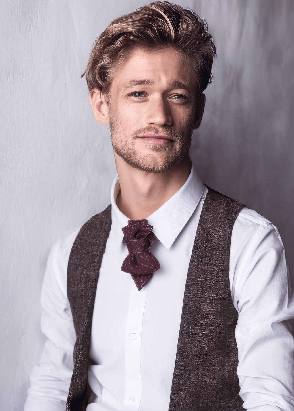 Man wearing a white shirt, brown vest, and burgundy bow tie against a gray background Bow Tie, Tie for wedding suite MERLOT II hopper tie Bow tie, groomer tie bordeaux bow tie, handmade necktie, luxury wedding tie, vertical layered tie, merlot color tie, groom accessory, elegant menswear, performer neckwear, artistic bow tie, chevron pattern tie, red wine color tie, unique handmade tie, ruty design tie
