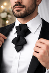 Man wearing a black bow tie and white shirt with a blurred background Handmade black hopper tie for wedding, original designer bow tie on white shirt, Luxury black wedding hopper tie, modern bow tie and necktie hybrid, Elegant handmade hopper tie for groom, minimalist black formal accessory, Original design black hopper tie, premium wedding bow tie for men, Modern black hopper tie for formal wear, handcrafted wedding neck accessory, Designer handmade hopper tie, sophisticated black tie