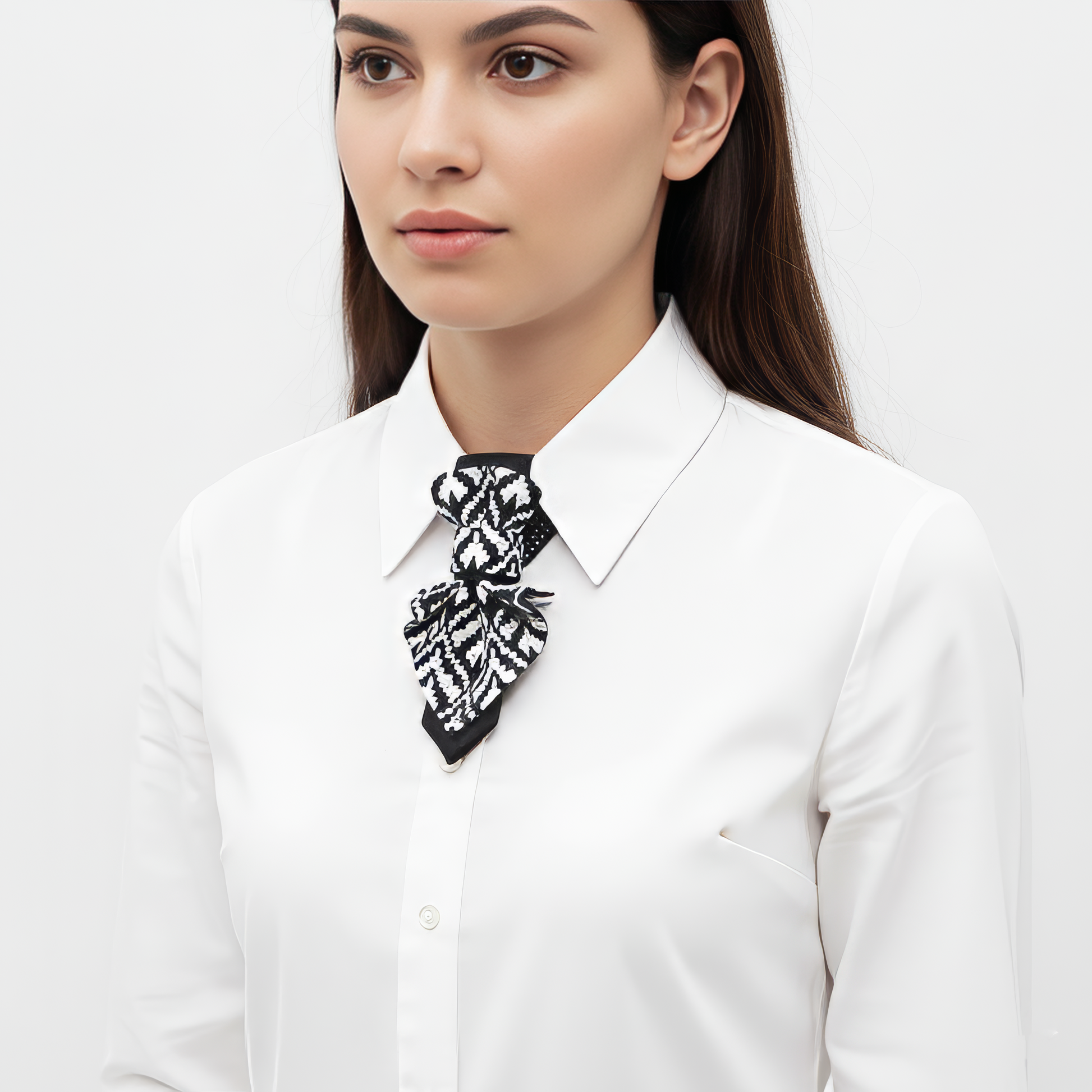 Woman wearing a white shirt with a black and white patterned scarf around her neck against a white background