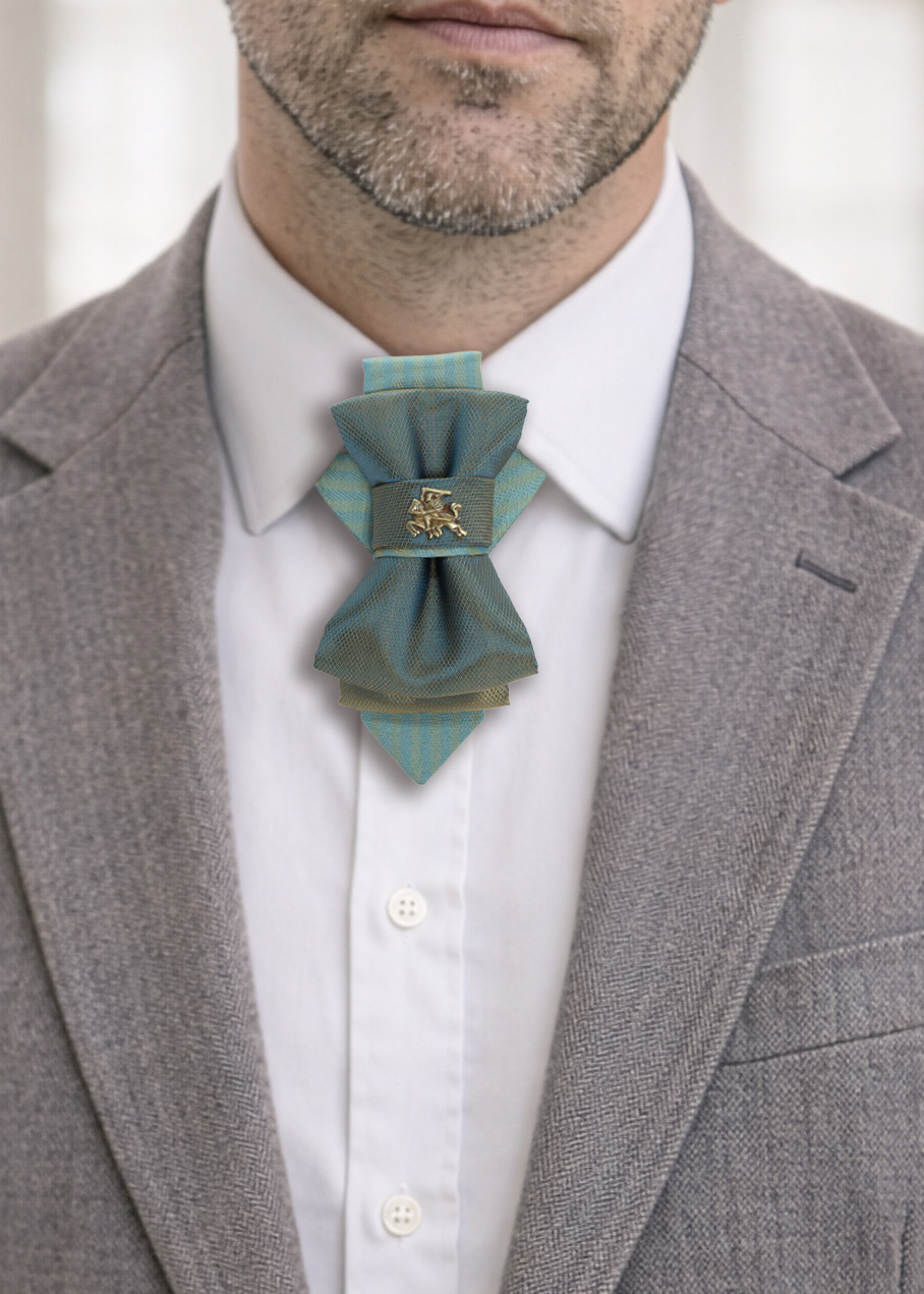 Man wearing a gray suit with a white shirt and a decorative blue bow tie handmade luxury hopper tie, 13 cm vertical bow tie necklace, unique designer neck accessory, teal and gold fabric tie with metal pin, modern unisex statement tie, artistic wedding neckwear, groom alternative tie, minimalist luxury fashion accessory, handcrafted european design neckpiece