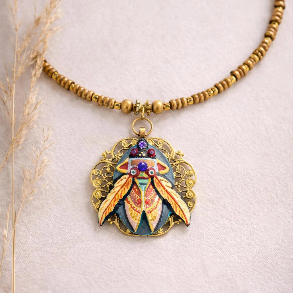 Decorative necklace with a colorful pendant on a light background one of a kind hand painted art necklace, luxury wearable art jewelry, miniature oil painting beetle pendant, handmade artist jewelry, unique statement necklace, fine art jewelry, hand painted miniature under microscope, professional artist made pendant, gold filigree necklace, collectible wearable artwork, elegant artistic necklace for everyday and special occasions