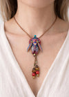 Necklace with a colorful pendant and beads worn by a person in a white top unique gift for her, art lover gift, handmade jewelry gift, collectible art necklace, luxury statement gift, anniversary gift idea, birthday gift for wife, gift for creative woman, meaningful artistic jewelry, museum style pendant gift, renaissance inspired necklace, fantasy insect jewelry, heirloom style accessory, artisan designer necklace, special occasion jewelry, romantic gift idea, Christmas gift for her, Valentine gift jewelry