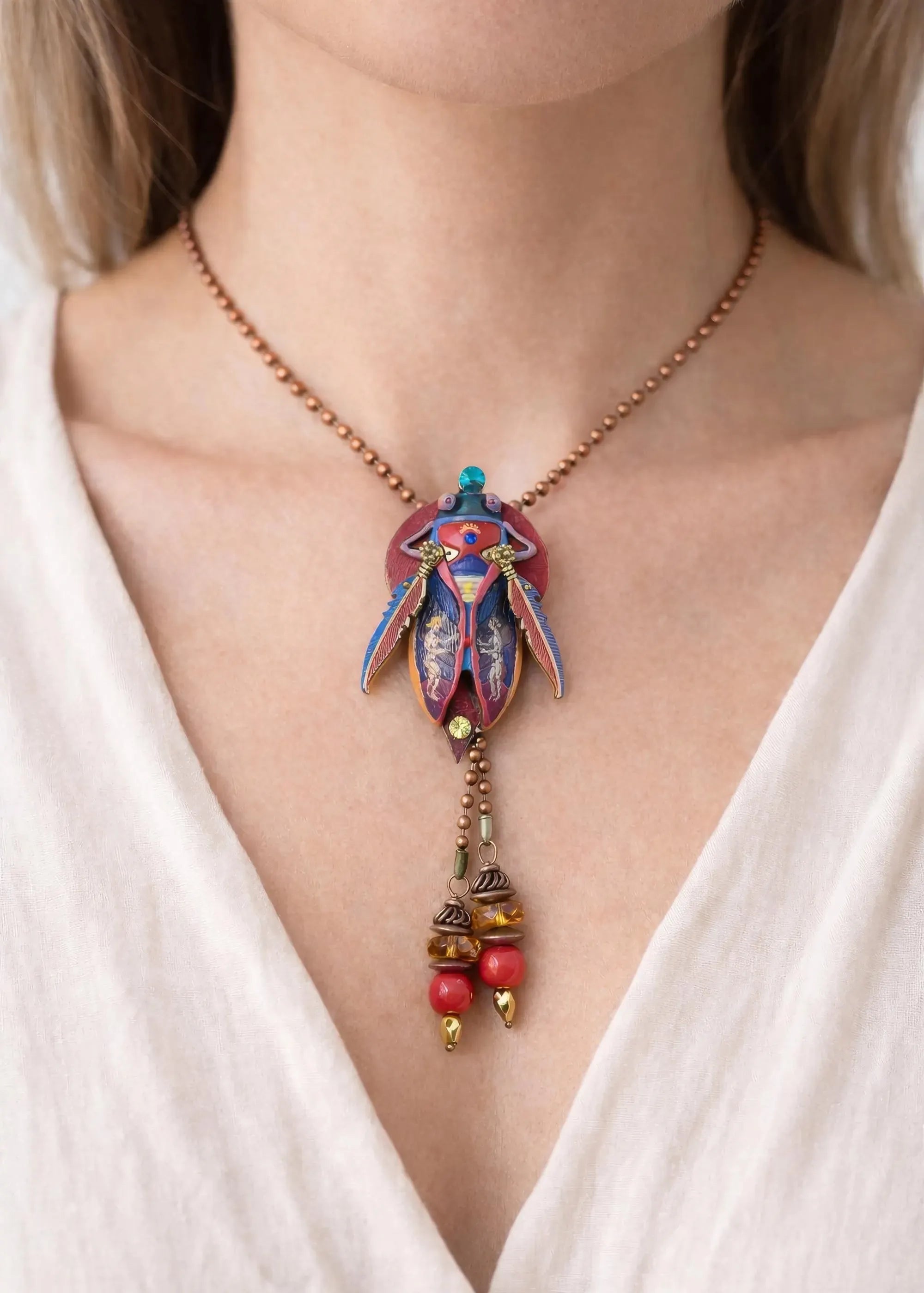 Necklace with a colorful pendant and beads worn by a person in a white top unique gift for her, art lover gift, handmade jewelry gift, collectible art necklace, luxury statement gift, anniversary gift idea, birthday gift for wife, gift for creative woman, meaningful artistic jewelry, museum style pendant gift, renaissance inspired necklace, fantasy insect jewelry, heirloom style accessory, artisan designer necklace, special occasion jewelry, romantic gift idea, Christmas gift for her, Valentine gift jewelry