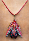 Colorful pendant necklace with intricate design on a red cord against a beige background hand painted scarab necklace red black pendant, statement insect neck accessory, unique artist jewelry for women, bold red cord pendant necklace, wearable art beetle pendant, handmade enamel scarab charm, artistic fashion necklace close up, one of a kind insect jewelry, luxury artisan pendant for art lover, red gemstone scarab necklace, contemporary statement neckpiece, collectible art jewelry pendant, designer handmade