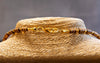 Close-up of a straw hat with decorative band against a gray background