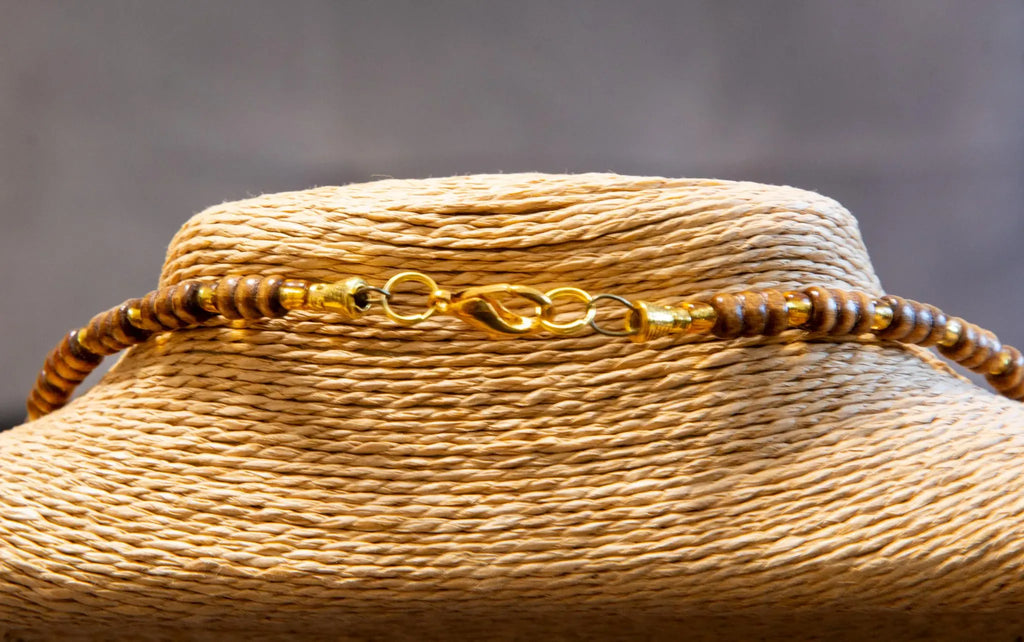 Close-up of a straw hat with decorative band against a gray background