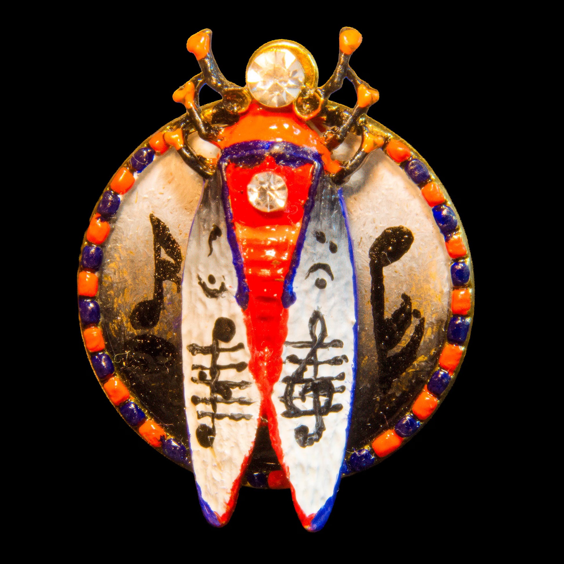 Decorative pendant with intricate designs on a black background