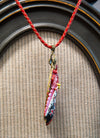 Necklace with a colorful pendant on a textured surface