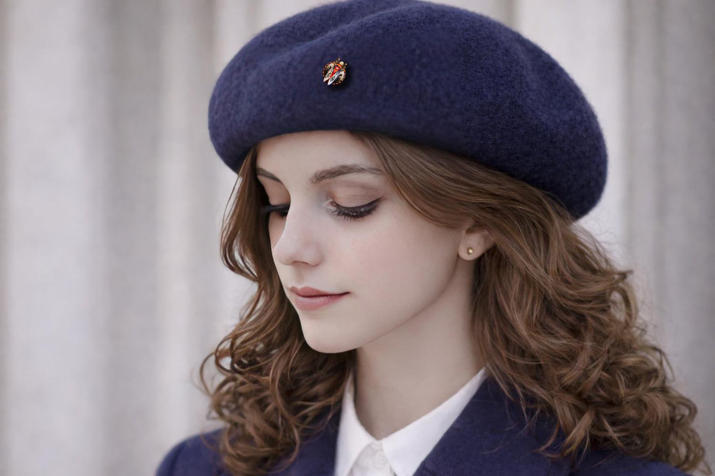 Woman wearing a navy blue beret with a small decorative emblem against a neutral background Musical scarab brooch with hand painted music notes, unique artist beetle pin white background, handmade luxury music themed brooch, original art jewelry for musician gift, one of a kind painted insect brooch, red blue gold statement accessory, wearable art scarab with notes motif, artistic music lover brooch gift, handcrafted collectible beetle pin, exclusive small batch art jewelry