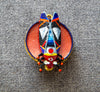 Colorful butterfly-shaped pendant on a textured gray background hand painted scarab brooch red black beetle pin, unique artist statement jewelry, one of a kind wearable art brooch, luxury enamel insect pin, bold red black scarab accessory, handmade artistic beetle badge, sculptural statement brooch for blazer, collectible art lover gift jewelry, textured enamel scarab pin, designer insect brooch with gold accents, contemporary art jewelry piece, high quality handmade brooch, distinctive fashion statement pi