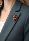 Close-up of a person wearing a dark gray blazer with a decorative brooch on the lapel hand painted scarab brooch red black beetle pin, unique artist statement jewelry, one of a kind wearable art brooch, luxury enamel insect pin, bold red black scarab accessory, handmade artistic beetle badge, sculptural statement brooch for blazer, collectible art lover gift jewelry, textured enamel scarab pin, designer insect brooch with gold accents, contemporary art jewelry piece, high quality handmade brooch