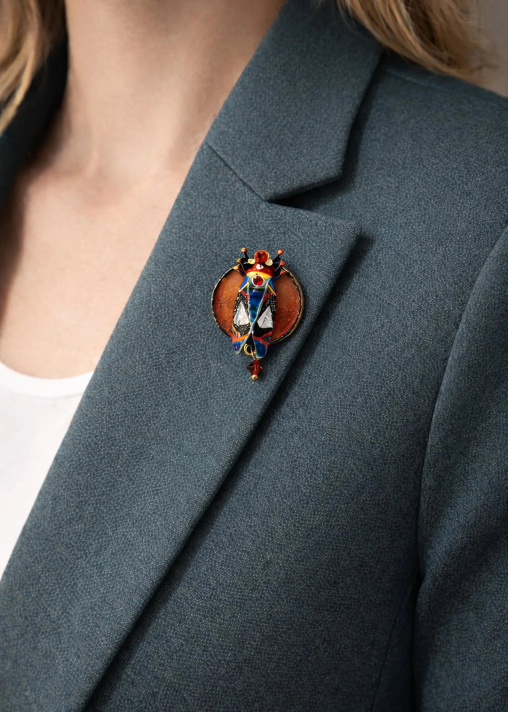 Close-up of a person wearing a dark gray blazer with a decorative brooch on the lapel hand painted scarab brooch red black beetle pin, unique artist statement jewelry, one of a kind wearable art brooch, luxury enamel insect pin, bold red black scarab accessory, handmade artistic beetle badge, sculptural statement brooch for blazer, collectible art lover gift jewelry, textured enamel scarab pin, designer insect brooch with gold accents, contemporary art jewelry piece, high quality handmade brooch