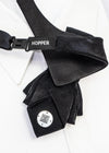 Black bow tie with 'Hopper' branding on a white background black statement tie for men, sculptural bow tie alternative, unique formal neckwear, artistic groom tie, modern wedding tie, luxury handmade necktie, sophisticated men fashion, elegant men accessory, designer neckwear piece, standout wedding look, contemporary cravat style tie, tailored suit accessory, refined black necktie, avant garde tie, formal event accessory, minimalist black tie, premium fabric tie, stylish groom outfit detail