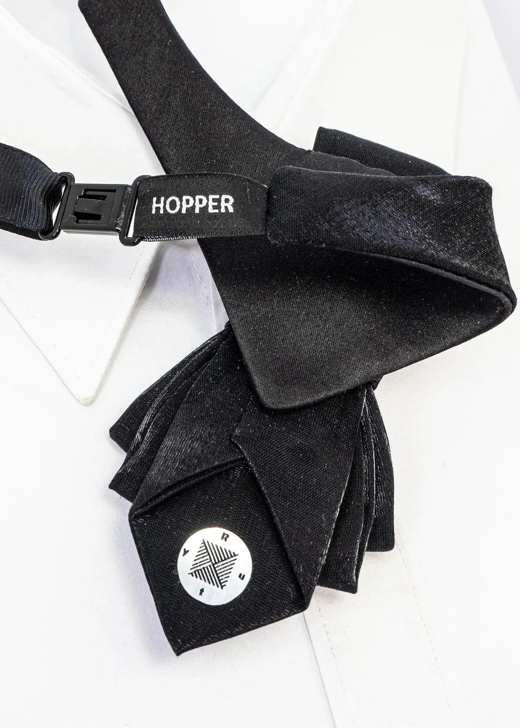 Black bow tie with 'Hopper' branding on a white background black statement tie for men, sculptural bow tie alternative, unique formal neckwear, artistic groom tie, modern wedding tie, luxury handmade necktie, sophisticated men fashion, elegant men accessory, designer neckwear piece, standout wedding look, contemporary cravat style tie, tailored suit accessory, refined black necktie, avant garde tie, formal event accessory, minimalist black tie, premium fabric tie, stylish groom outfit detail