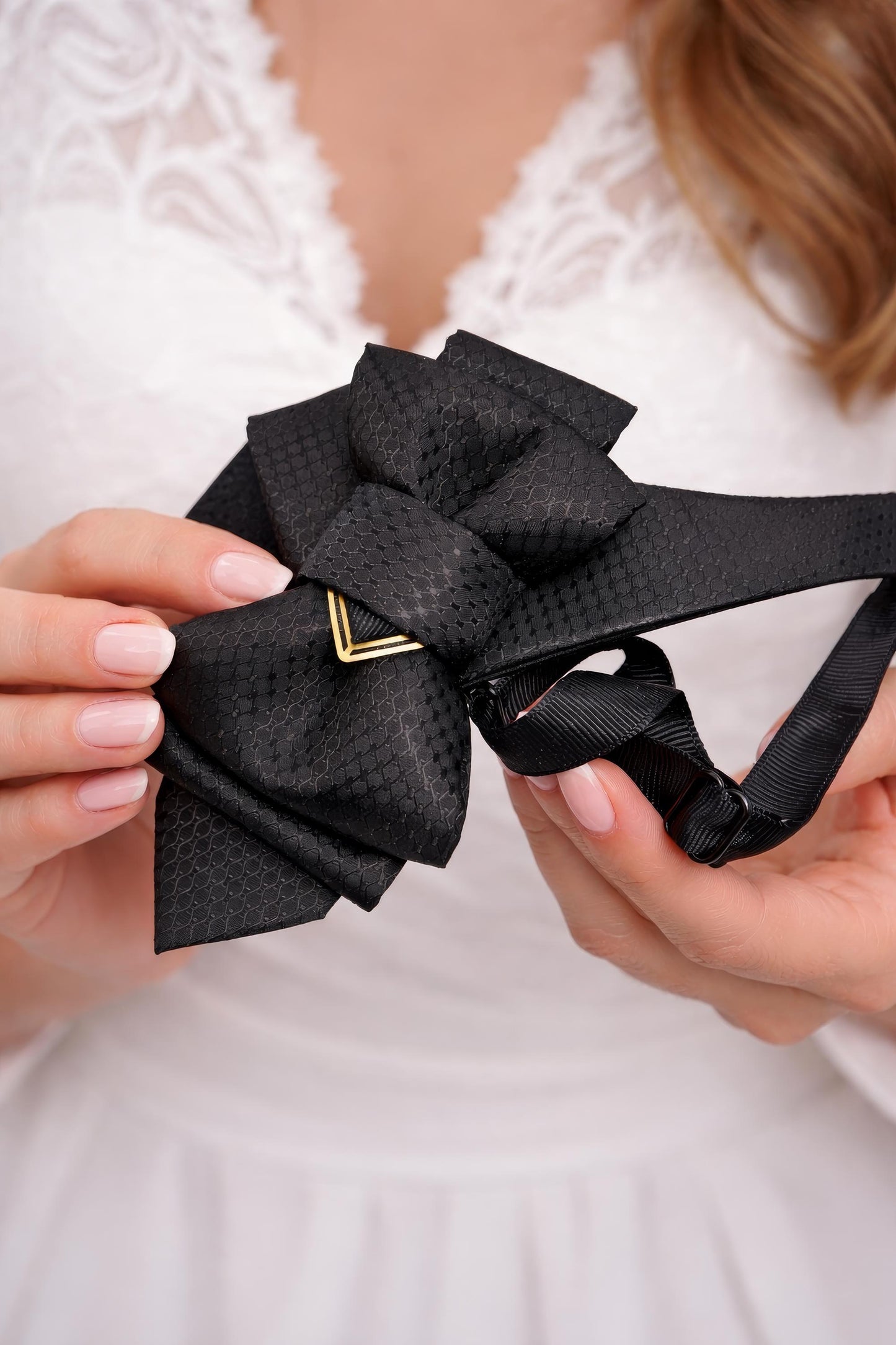 Black bow tie held by hands against a blurred white background Man in a formal suit standing in a train station Handmade luxury black bow tie for weddings, Black wedding bow tie, Unique artistic black necktie for stylish men, Designer black bow tie for grooms and musicians, Elegant black wedding bow tie by Rūta Piekurienė, High-end handmade black tie for special occasions, Artistic luxury black bow tie for men, Unique wedding bow tie crafted by Rūta Piekurienė, Handmade black necktie for formal elegant look