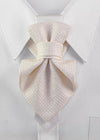 A light cream or off-white textured necktie knotted in a bow style, displayed on a white dress shirt collar Luxury handmade white Hopper Tie neck accessory for women displayed on a crisp white shirt collar. Elegant textured fabric statement tie with a minimalist satin accent, handcrafted for brides, weddings, business elegance, formal occasions, and modern fashion. Premium artisan designer neckwear showcasing timeless couture craftsmanship and sophisticated style.