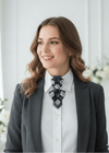 Woman wearing a gray blazer and white shirt with a decorative black and gray necklace in a bright room Handmade luxury argyle necktie, unique sculptural design, original women's special occasion and everyday neck accessory, fixed non-traditional construction, worn with white shirt and grey blazer, ideal for Etsy product listing, realistic lighting.