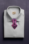 Folded light gray shirt with a purple bow tie and gold rings on a dark background