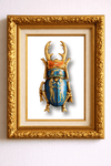 Decorative beetle sculpture with gold and blue details in a gold frame on a white background