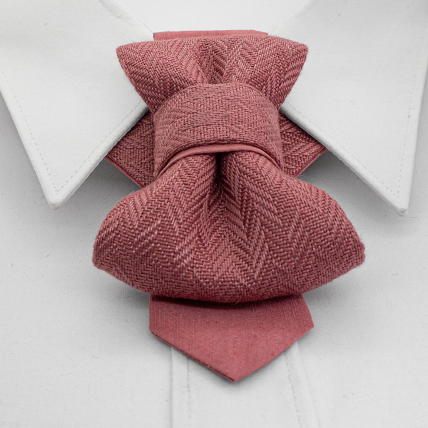 Pink textured bow tie on a white shirt with a white background