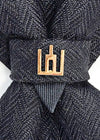 Black patterned tie with a gold clasp background Handmade luxury dark navy blue wool bow tie with leather neck strap and unique gold-tone monogrammed clip. Pre-tied cravat for groom, weddings, formal events, and special occasions. Perfect sophisticated men's accessory.