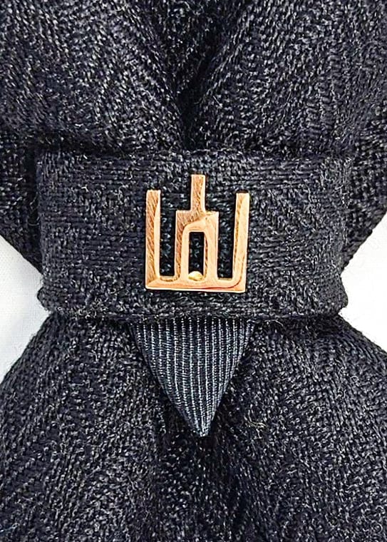 Black patterned tie with a gold clasp background Handmade luxury dark navy blue wool bow tie with leather neck strap and unique gold-tone monogrammed clip. Pre-tied cravat for groom, weddings, formal events, and special occasions. Perfect sophisticated men's accessory.
