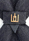 Black patterned tie with a gold clasp background Handmade luxury dark navy blue wool bow tie with leather neck strap and unique gold-tone monogrammed clip. Pre-tied cravat for groom, weddings, formal events, and special occasions. Perfect sophisticated men's accessory.