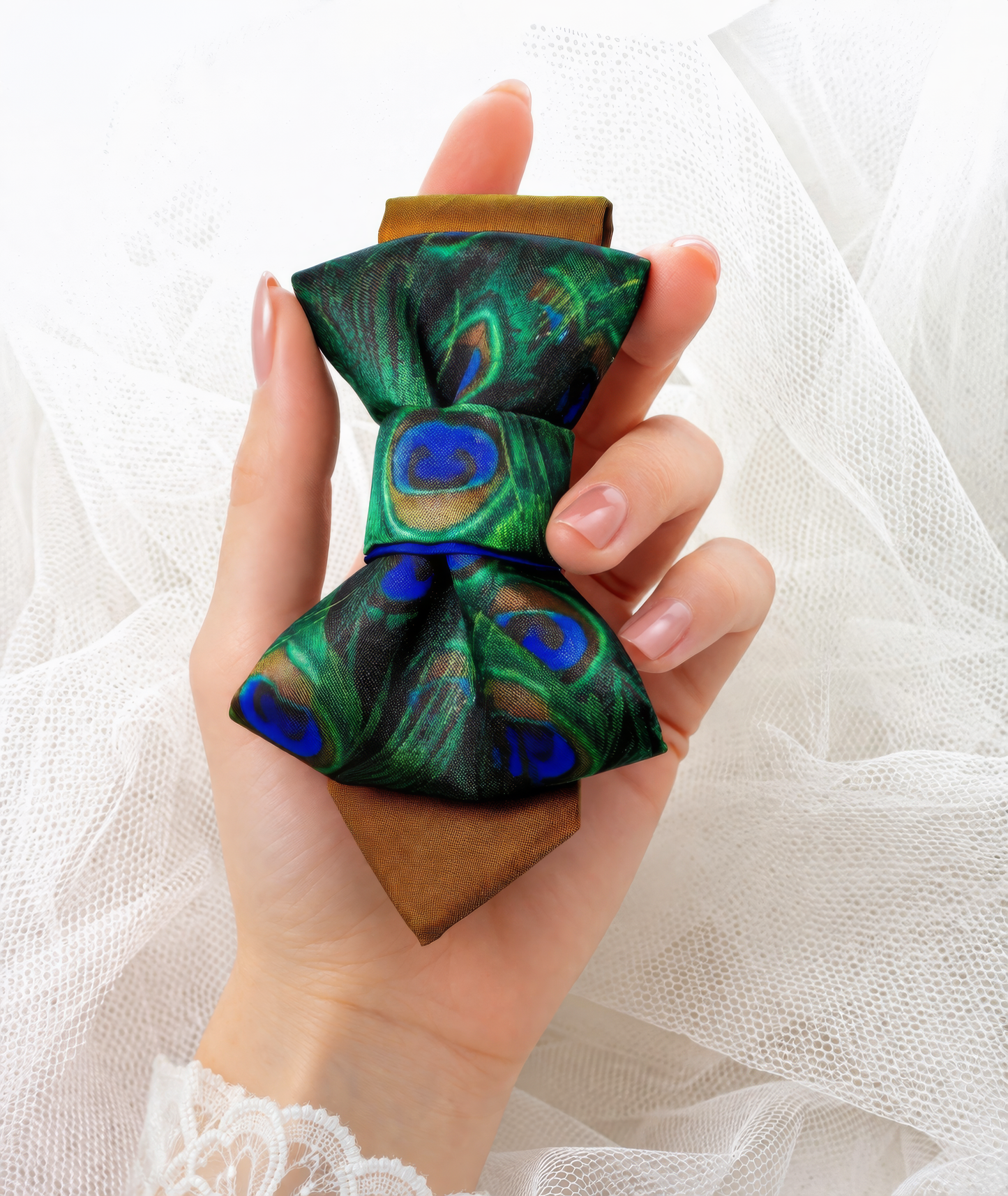 Hand holding a peacock feather bow tie against a white background Woman wearing a stylish necklace with peacock feathers and a gray blazer peacock feather necklace, statement bow tie necklace, handmade silk accessory, green blue peacock pattern jewelry, artistic neckpiece, elegant women accessory, unique designer necklace, luxury handmade jewelry, modern bow necklace, bold statement piece, peacock motif fashion, gift for her unique jewelry, sustainable handmade accessory, artisan neckwear, teal green fashio