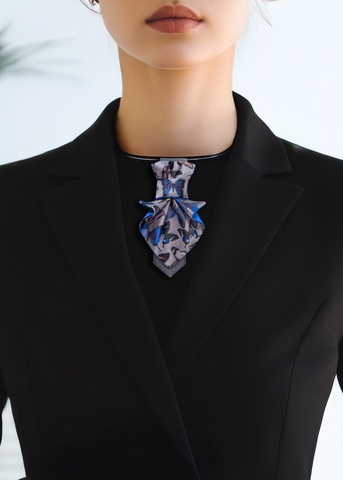 Person wearing a black blazer with a patterned tie against a blurred indoor background Jabot Blue tie for women, Blue bow tie for ladies Handmade luxury women’s necktie “Butterfly” – elegant gray and blue accessory with butterfly pattern, combining tie and bow style, perfect for weddings, musicians, and artistic women.