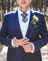 uxury handmade ascot tie close up, navy blue paisley ascot tie, silk ascot tie on white shirt, men formal neckwear detail, elegant cravat tie front view, artisan made ascot tie, premium men neck accessory, wedding groom ascot tie, stage performer formal tie, unique paisley necktie texture, luxury menswear accessory closeup, sophisticated formal tie design